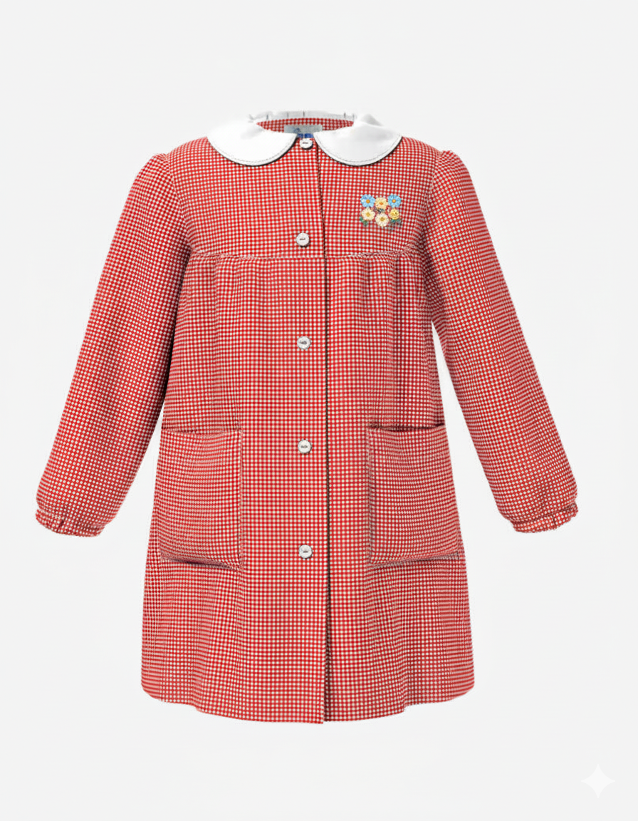 Grembiule da asilo con ricamo  per bambina in  rosso a quadretti, caratterizzato da un colletto bianco a contrasto, allacciatura centrale con bottoni, due ampie tasche laterali e polsini elasticizzati.