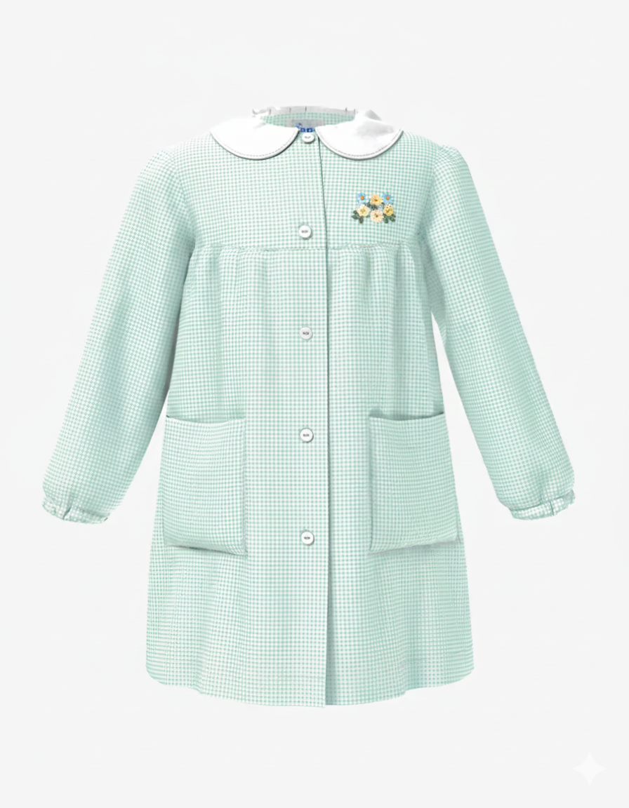 Grembiule da asilo con ricamo  per bambina in  verde a quadretti, caratterizzato da un colletto bianco a contrasto, allacciatura centrale con bottoni, due ampie tasche laterali e polsini elasticizzati.