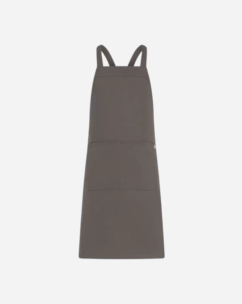 Grembiule unisex tortora in poliestere e cotone con pettorina, tasca centrale e allacciatura con bretelle regolabili tramite anello in ottone.