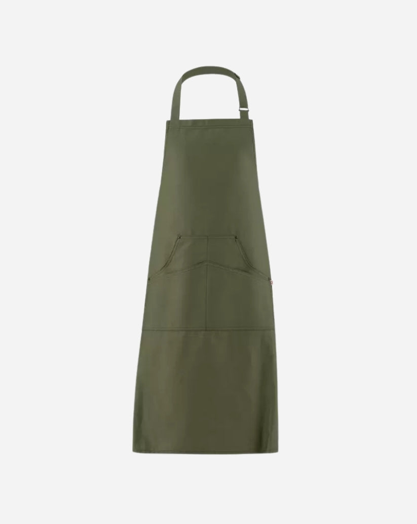 Grembiule a pettorina verde militare in twill di cotone con fibbia regolabile in ottone, tasca centrale e rivetti antichi.