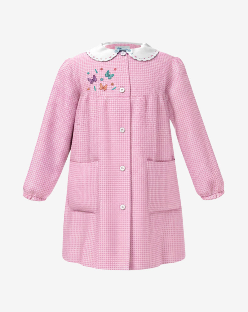 Grembiule da asilo con ricamo  per bambina in  rosa a quadretti, con  colletto bianco a contrasto, allacciatura centrale con bottoni, due  tasche laterali e polsini elasticizzati.