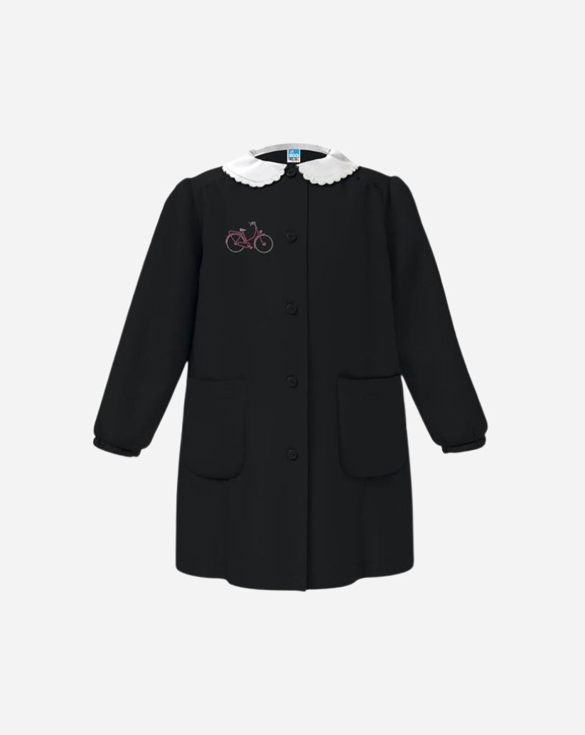 Grembiule bimba nero in poliestere e cotone con colletto bianco, ricamo , bottoni centrali e due tasche.