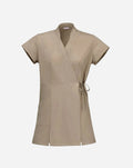 Kimono beige a manica corta con tasca laterale, doppia allacciatura in vita e spacchi laterali per facilitare il movimento.